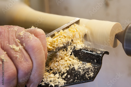 Wood turning. Close up of a carpenter turning wood on a lathe photo