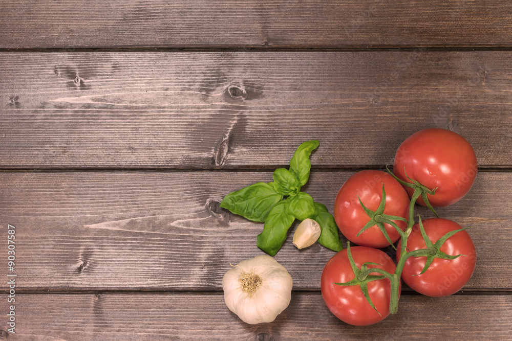 Tomatoes, garlic and basil on a wooden desk Tomatoes, garlic and basil on a wooden desk