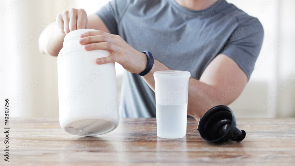 close up of man with protein shake bottle and jar