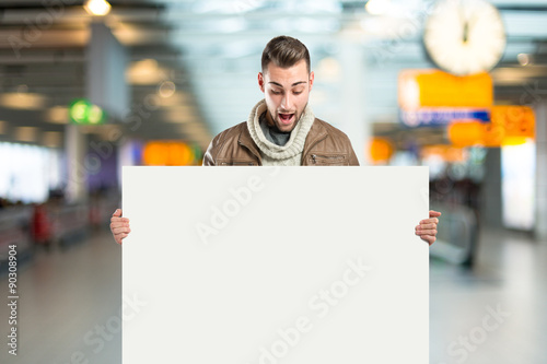 handsome man holding an empty cardboard over white background