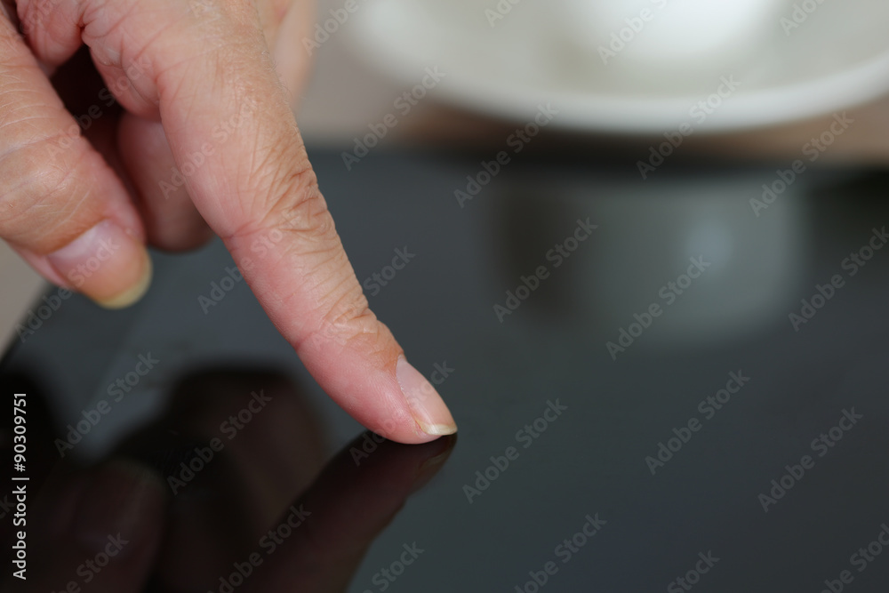 Female hand pointing in black tablet pc