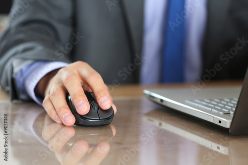 Hands of businessman in suit holding computer wireless mouse