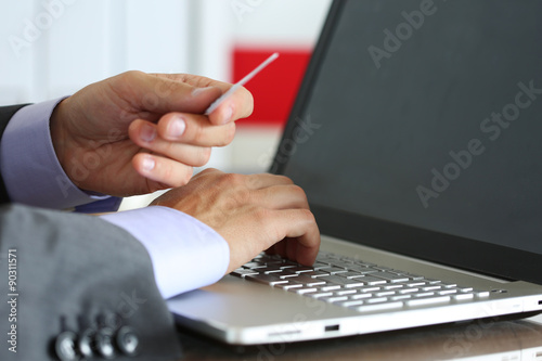 Hands of businessman in suit holding credit card