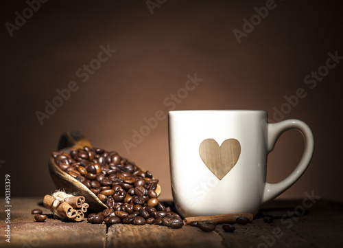 White cup with heart and coffee beans