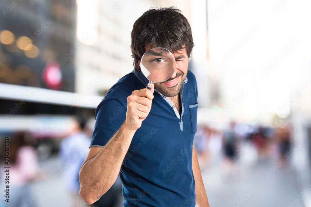 Man with magnifying glass over white background