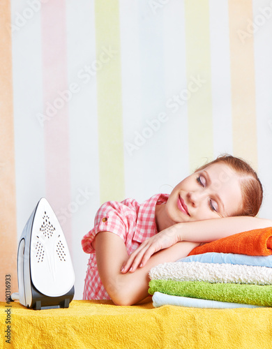 tired housewife fell asleep on ironing board with iron