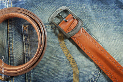 leather belt on blue jeans background