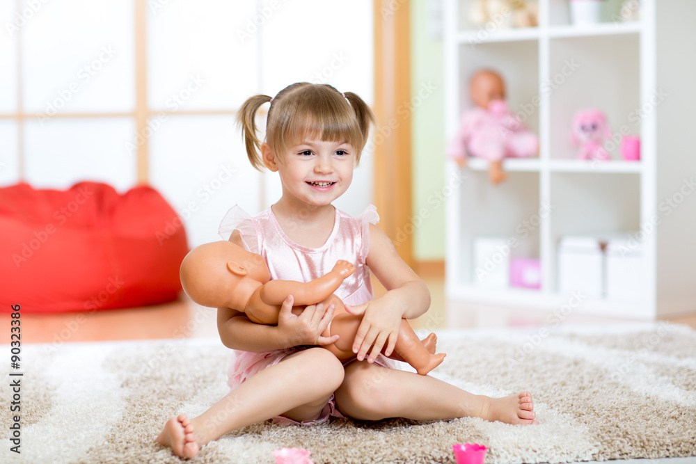 Cute little girl holding and embracing her doll