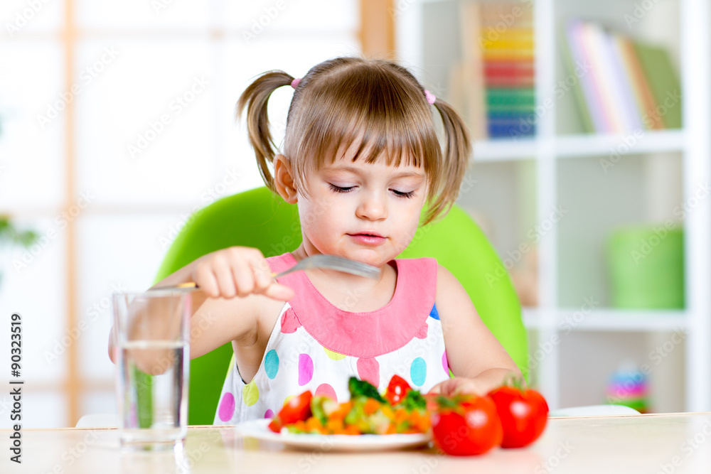 Kid girl eats fresh vegetables. Healthy eating for child