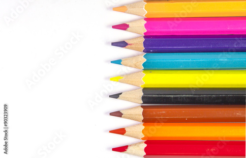 Line of colored pencils isolated on white background close up