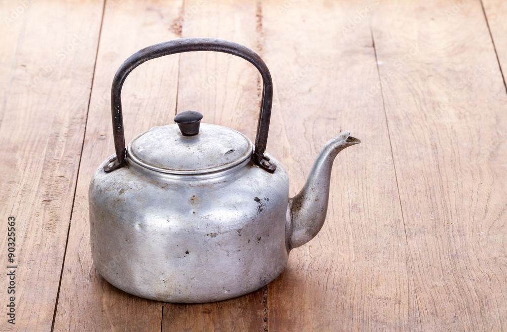 dirty classic aluminum kettle on wooden background
