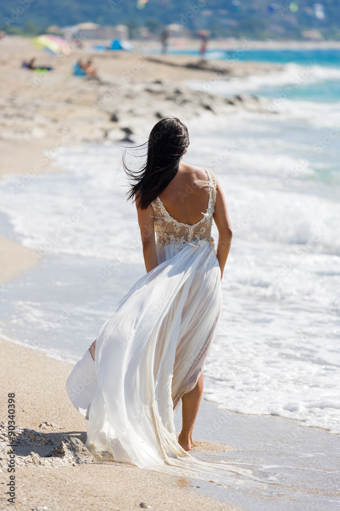 Beautiful young bride walking on the beach Beautiful young bride walking on the beach