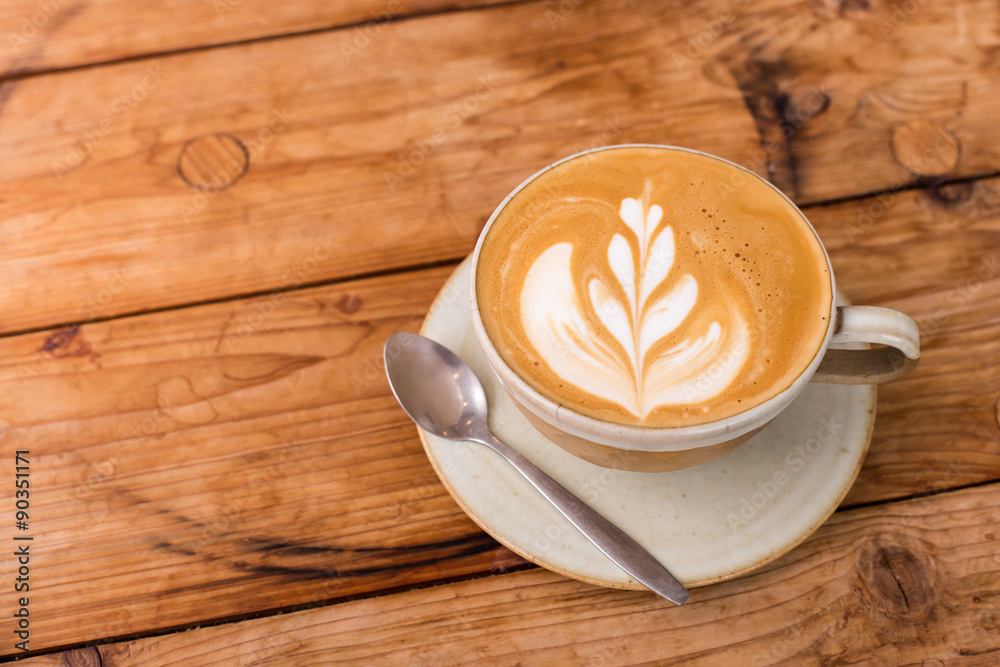 Obraz premium Hot art Latte Coffee in a cup on wooden table.