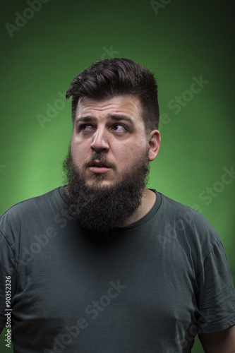 Confused man portrait, looking to right side. Green screen backg