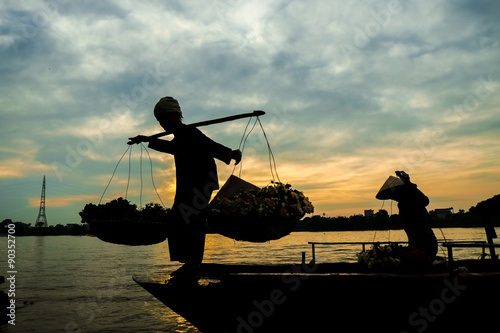 Vietnam woman florist vendor on a boat in early moring