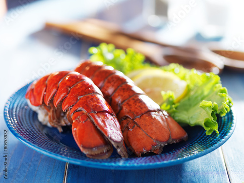 Canvas Print two lobster tails on blue plate with garnish for dinner