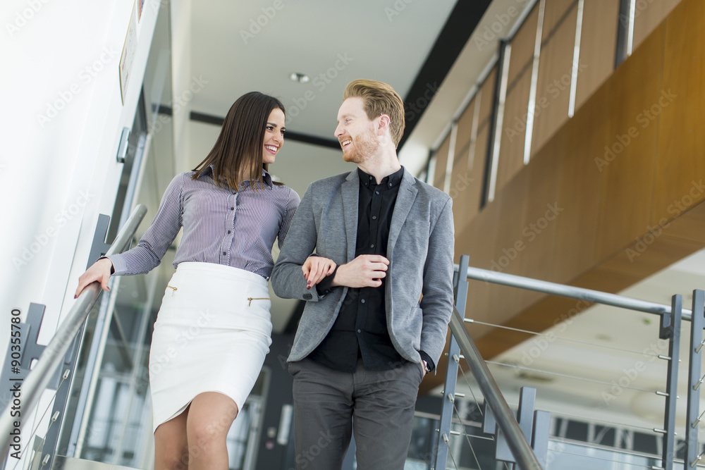 Naklejka premium Young couple on the stairs in office