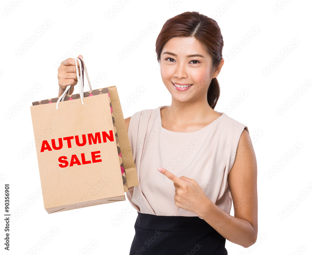 Asian woman finger point to shopping bag and showing phrase autu Asian woman finger point to shopping bag and showing phrase autu