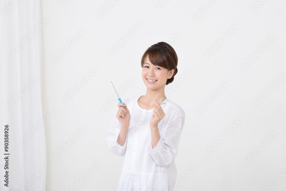 ネジとドライバーを持つ女性 ネジとドライバーを持つ女性