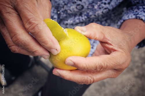  Senior woman eating orange fruit