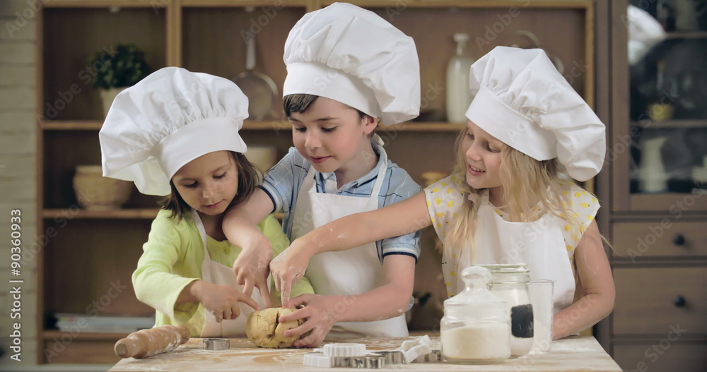 Cute little bakers poking holes in dough ball Cute little bakers poking holes in dough ball