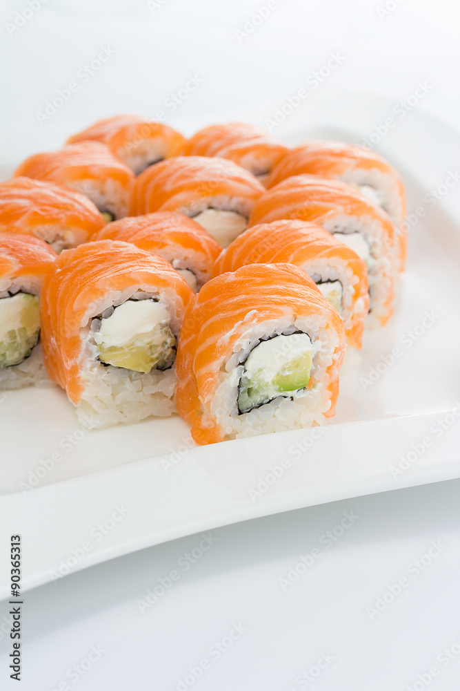 Salmon (philadelphia) sushi roll on a white plate with ginger and wasabi Salmon (philadelphia) sushi roll on a white plate with ginger and wasabi