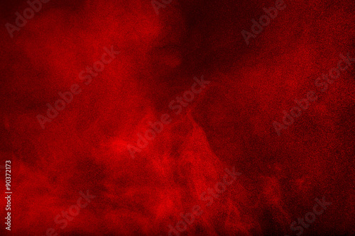 Red powder cloud against dark background