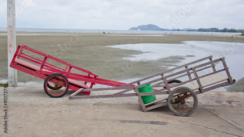 Two wheelbarrow with wooden handles on a beach
