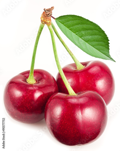 Three ripe red cherries on the white background.