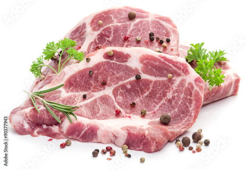 Raw pork meat steaks with spices on the white background.