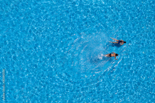 Aerial view of a two girls swimming in the pool