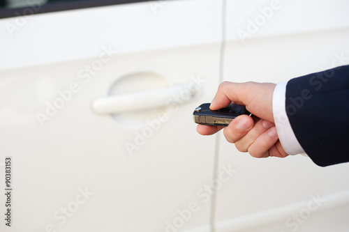 Men's hand with key unlocking car door