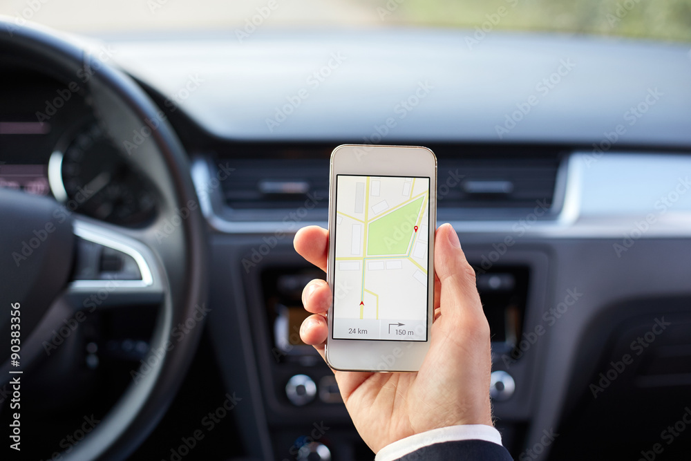 Male driver sitting in the car and holding white mobile phone with map gps navigation Male driver sitting in the car and holding white mobile phone with map gps navigation