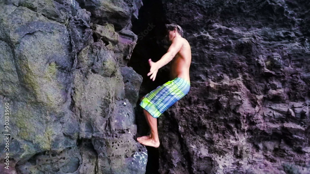 Extremely High Back Flip SLOW MOTION Cliff Jump into Water in front of a Sea Cave. Beautiful Sunny Day in Summer in Hawaii. Extremely High Back Flip SLOW MOTION Cliff Jump into Water in front of a Sea Cave. Beautiful Sunny Day in Summer in Hawaii.