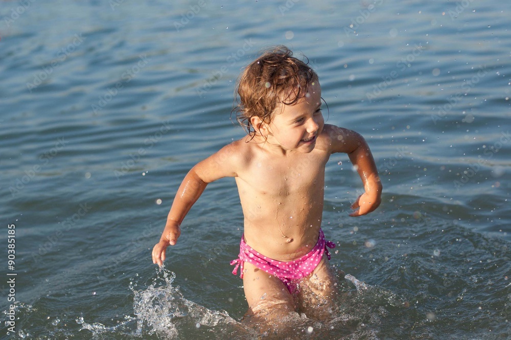 Little girl splashing in a lake