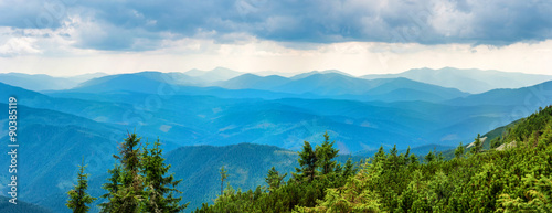 Blue mountains covered with green forest. Panorama view of peaks ridge © Pavlo Vakhrushev
