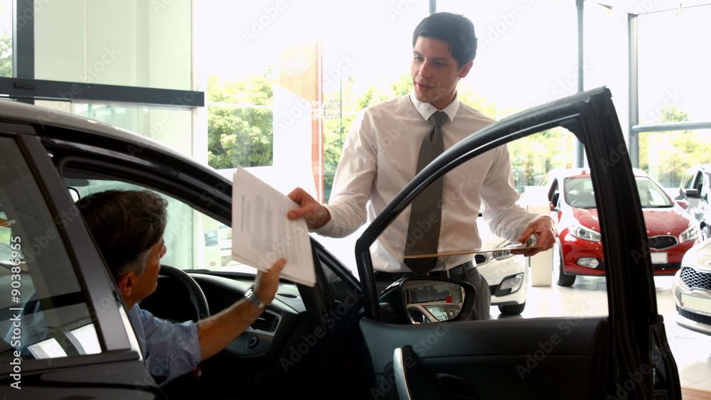Businessman explaining the car details Businessman explaining the car details