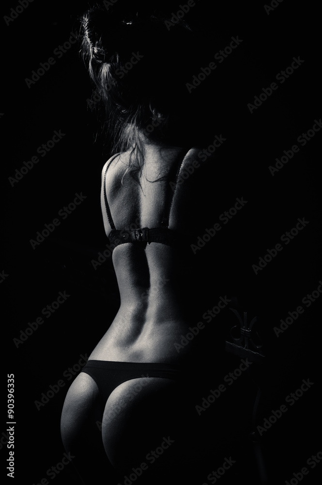 Obraz premium Perfect female showing her buttocks over dark background