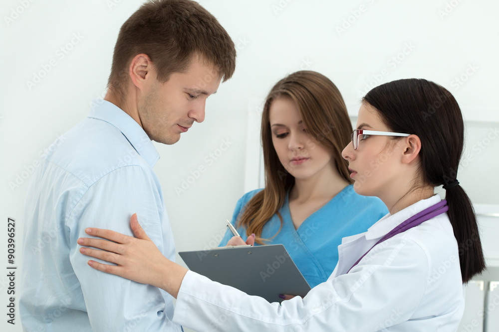 Friendly female doctor touching male patient's arm for empathy Friendly female doctor touching male patient's arm for empathy