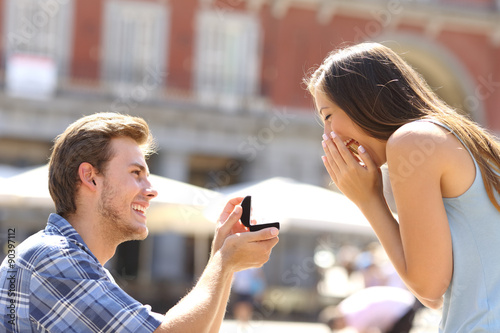 Fototapet Proposal in the street man asking marry to his girlfriend