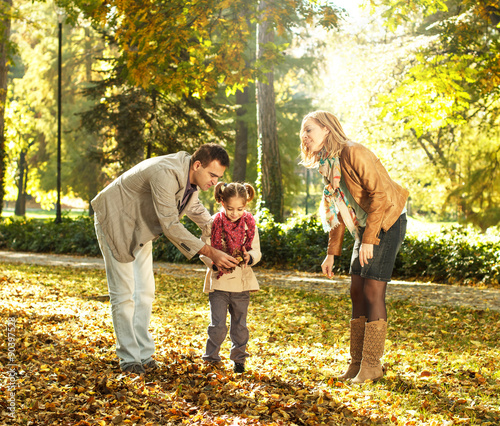 Cheerful family of three enjoying in a park on a sunny autumn day © Zoran Zeremski