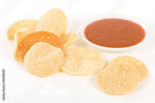 Poppadoms - Fried mini poppadoms on a white background. Served with chilli sauce.


