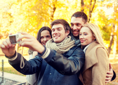 group of smiling men and women making selfie