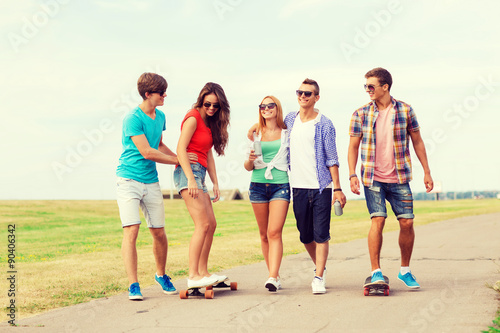 group of smiling teenagers with skateboards