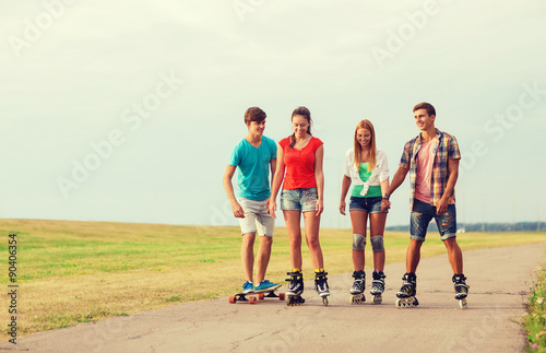 group of smiling teenagers with roller-skates
