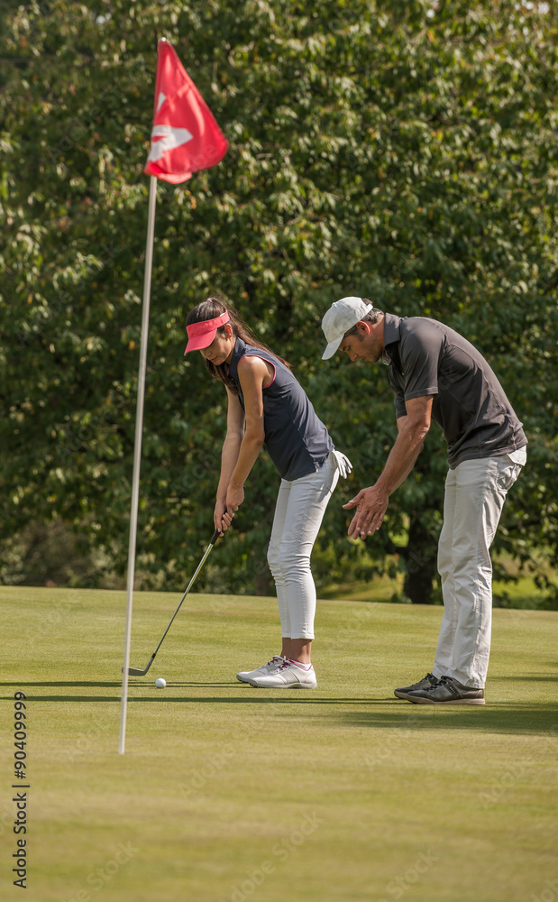 Obraz premium Nice couple playing golf in a sunny day on a nice course