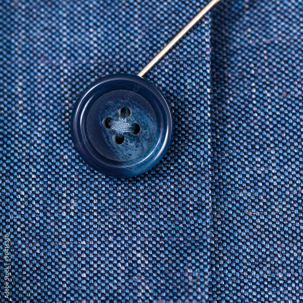 attaching of button to blue silk cloth by needle attaching of button to blue silk cloth by needle