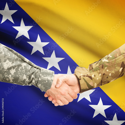 Men in uniform shaking hands with flag on background - Bosnia and Herzegovina