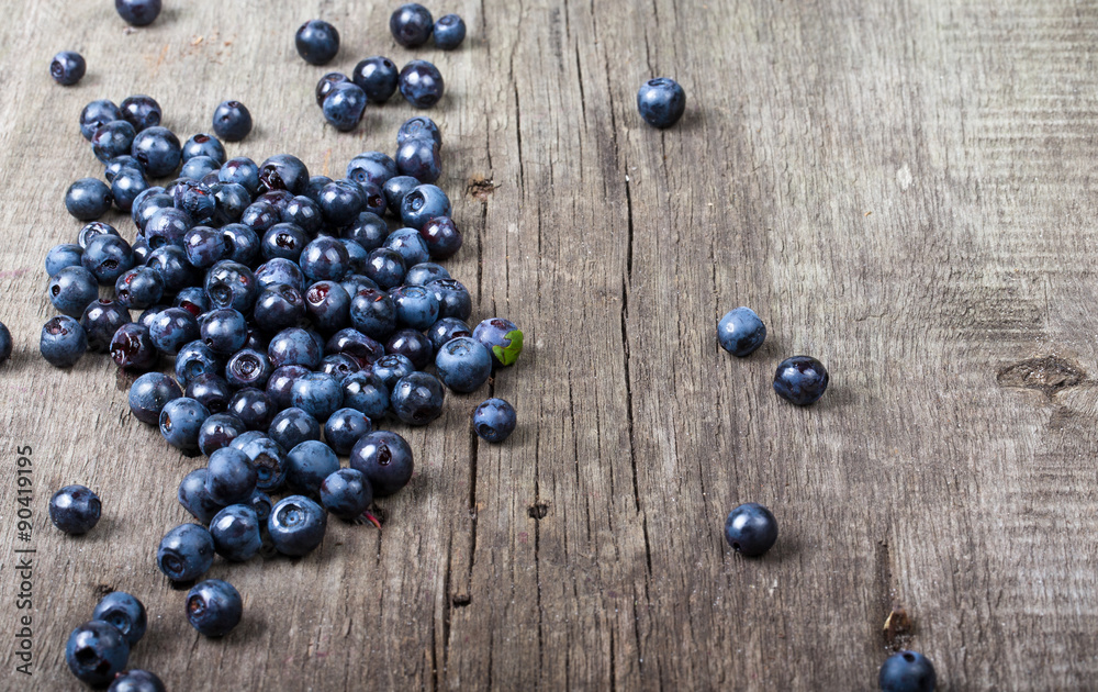 blueberries collected manually scattered on the old board. blueberries collected manually scattered on the old board.