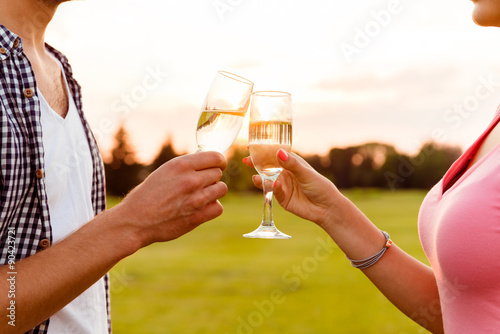 young couple drinking champagne at sunset